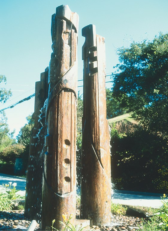 Made with fallen trees or driftwood, the vertical forms sculpted by Steve Kuntz evoke the classic totem poles of the Pacific Northwest, but they are eerily modern just the same.  This is particularly true in those cases where he includes running water as part of the composition, turning his sculptures into watershapes that explore the special relationship between wood and water in ways that are both soothing and surprising.