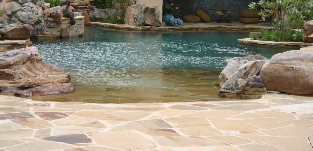 Any backyard project that encompasses tons of stone, hundreds of square feet of glass tile, a complex waterfall structure, a large bridge, an island spa and other features focused on fun, elegance and beauty is likely to be something special. In this case, it happens to be one of master watershaper David Tisherman’s most intricate achievements to date – one he guides us through in this pictorial, which captures the challenges as well as the glorious results of an enormous collaboration.