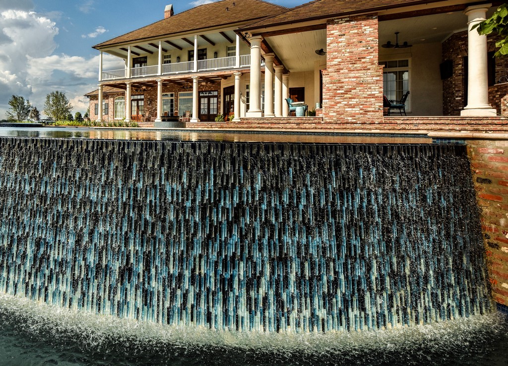 Project after project, making incredible complexity seem routine is what Jimmy Reed and his tile installers are all about. That unwavering finesse is particularly on display in this sublime poolscape, with its tilting, undulating vanishing-edge wall and uniquely configured spillover spa.